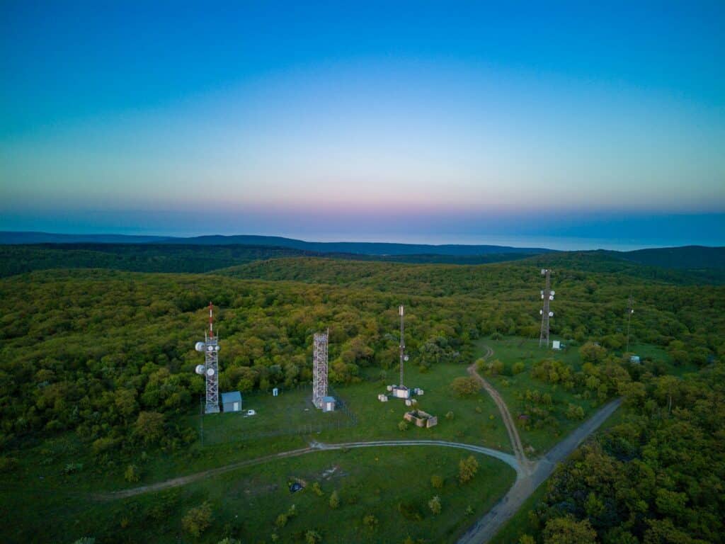 View of the hills covered with vegetation with cell towers against the backdrop